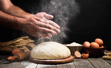 Des mains au-dessus d'une pâte à main