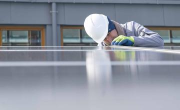 Un professionnel installe des panneaux solaires sur un toit