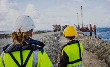Deux professionnelles sur un chantier regardent des engins