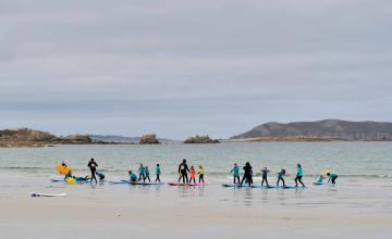 Cours de surf pour enfants sur une plage en Bretagne