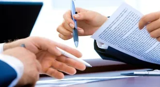 Les mains de 2 personnes qui discutent d'un document