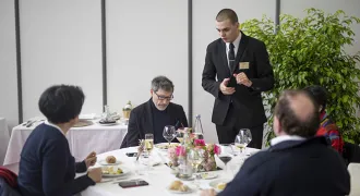 Un élève en formation en hôtelière sert des clients