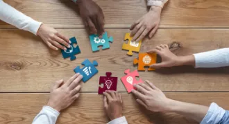 Plusieurs mains tiennent des pièces de puzzle