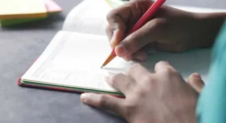 Main d'élève qui remplit un agenda