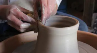 Mains qui travaillent sur un vase en céramique
