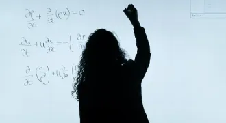 Une femme note des équations sur un panneau lumineux
