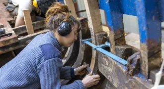 Jeune femme travaillant sur la charpente