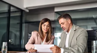 Deux personnes discutent à un bureau.