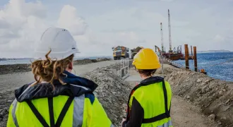 Deux professionnelles sur un chantier regardent des engins