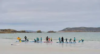 Cours de surf pour enfants sur une plage en Bretagne