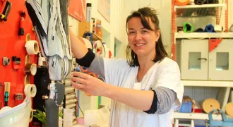 Agathe Le Gourières tient une prothèse de jambe sur l'établi de son atelier