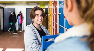 Deux élèves parlent devant des casiers