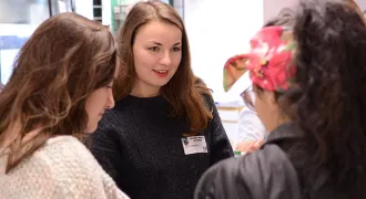 Une étudiante discute avec des lycéennes.
