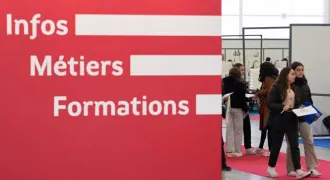 Vue d'un salon d'orientation avec un panneau indiquant "Infos métiers formations"