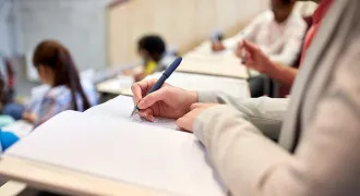 Des étudiants prennent des notes dans un amphi