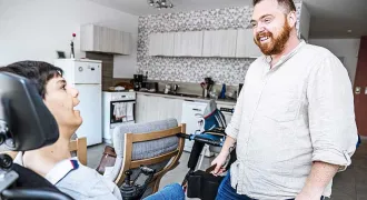 Un accompagnant éducatif et social parle avec une personne en situation de handicap