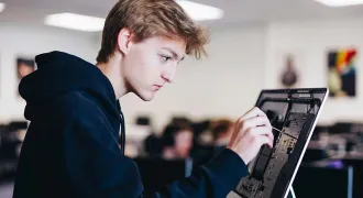 Un jeune stagiaire répare un ordinateur
