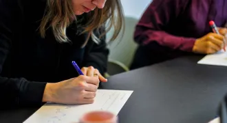 Des personnes autour d'une table prennent des notes