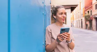 Une étudiante regarde son portable dans une ville étrangère