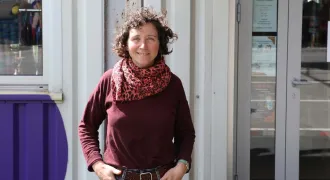 Portrait de Mélanie devant l'entrée de la ressourcerie