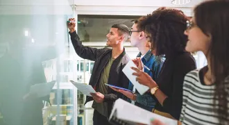 Des étudiants écrivent sur un tableau blanc
