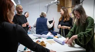 Des personnes autour d'une table avec des ciseau et un mètre mesureur