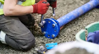 Des mains manipulant un tuyau et des outils