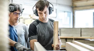 Deux stagiaires usinent un morceau de bois