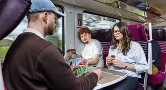 Des lycéens jouent aux cartes dans un train