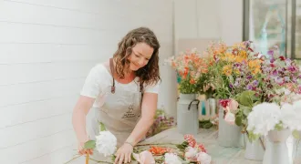 Tiphaine réalise un bouquet de fleurs sur une table
