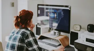 Une étudiante regarde son PC chez elle