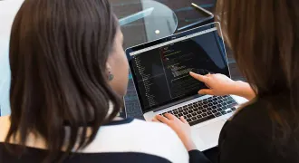Deux femmes de dos regardent un écran d'ordinateur