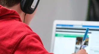 Un collégien de dos devant un ordinateur