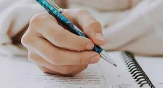 Une main écrit sur un agenda