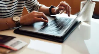 Des mains de femme tapent sur le clavier d'un PC portable