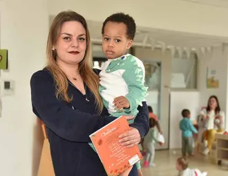 Victoria Morvan, auxiliaire de puériculture, tient un enfant dans ses bras
