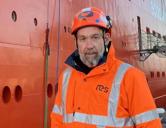 Portrait de Christophe Geimer dans un  port devant un navire