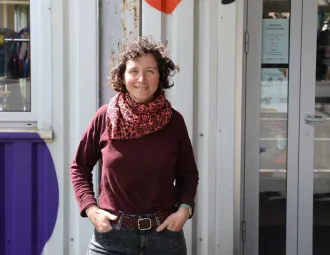 Portrait de Mélanie devant l'entrée de la ressourcerie