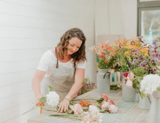 Tiphaine réalise un bouquet de fleurs sur une table