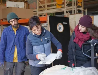 Marie note sur un cahier les références d'une fenêtre qui arrive en ressourcerie