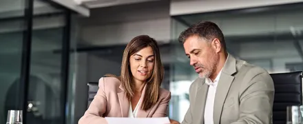 Deux personnes discutent à un bureau.