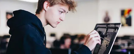 Un jeune stagiaire répare un ordinateur