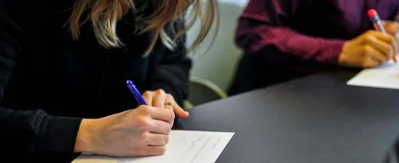 Des personnes autour d'une table prennent des notes