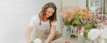 Tiphaine réalise un bouquet de fleurs sur une table