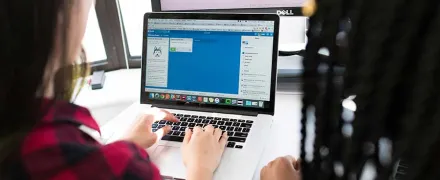 Une professionnelle travaille sur un écran avec une jeune à côté