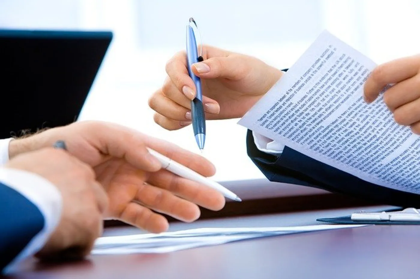 Les mains de 2 personnes qui discutent d'un document
