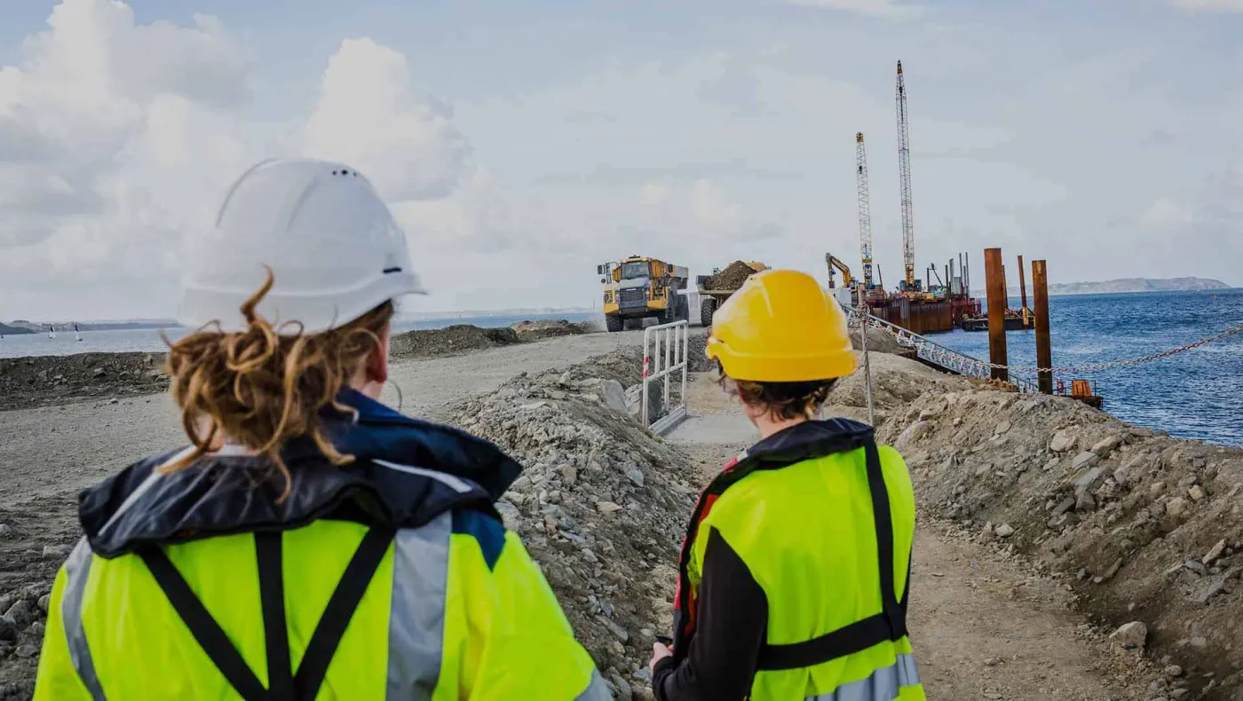 Deux professionnelles sur un chantier regardent des engins
