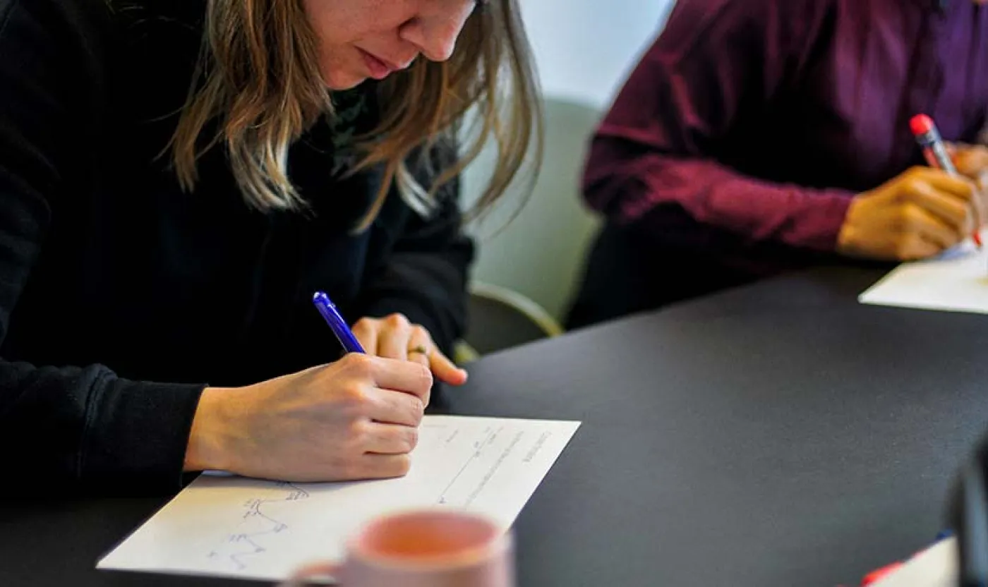 Des personnes autour d'une table prennent des notes