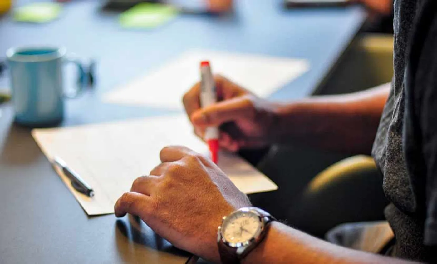 Une main écrit sur un cahier