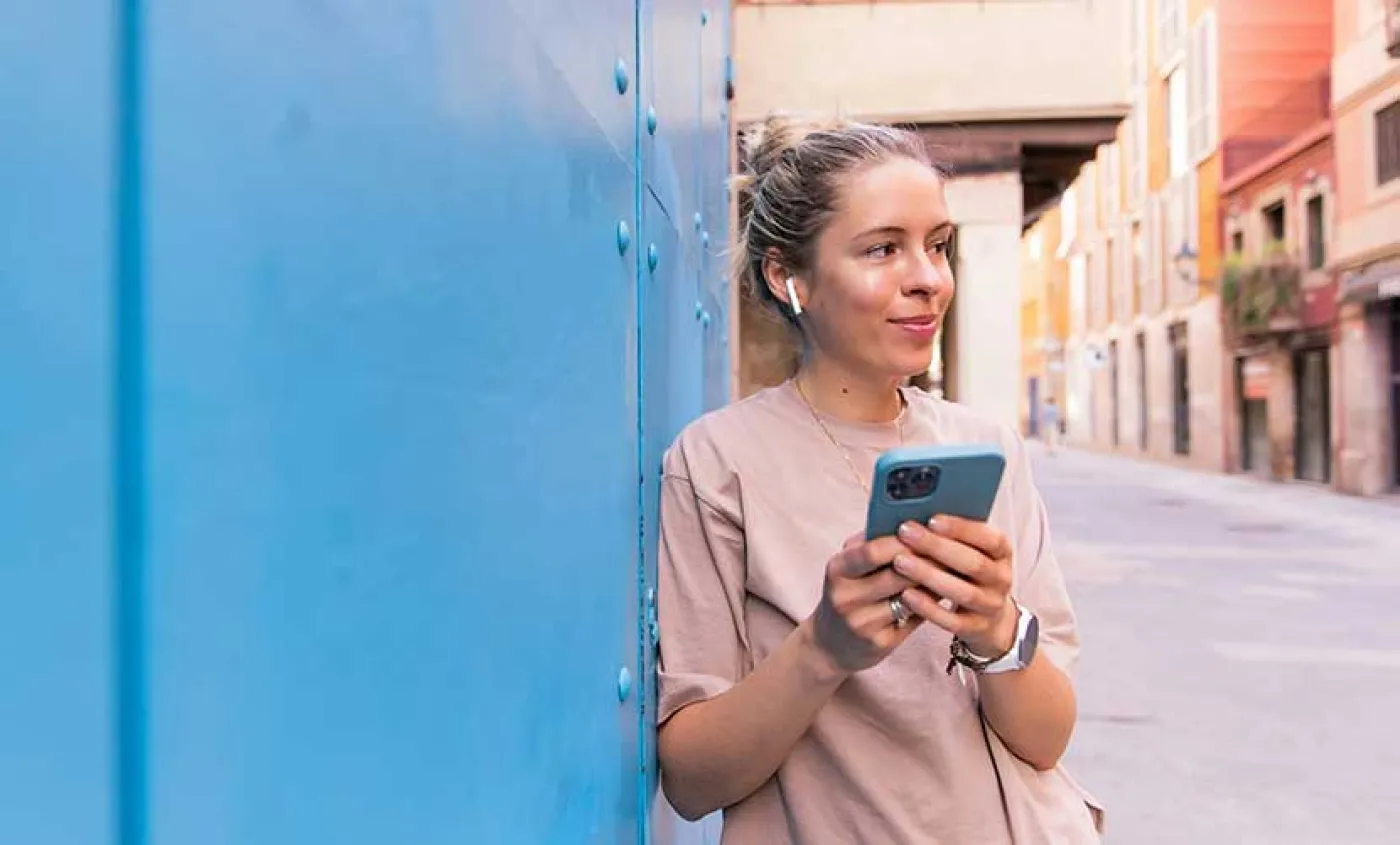 Une étudiante regarde son portable dans une ville étrangère